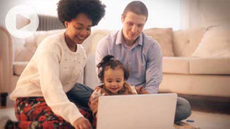 A man and woman with a child at a laptop.