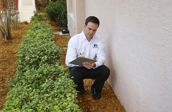 A technician taking notes on a clipboard.