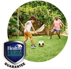 People playing soccer with the Healthy Home Guarantee badge.