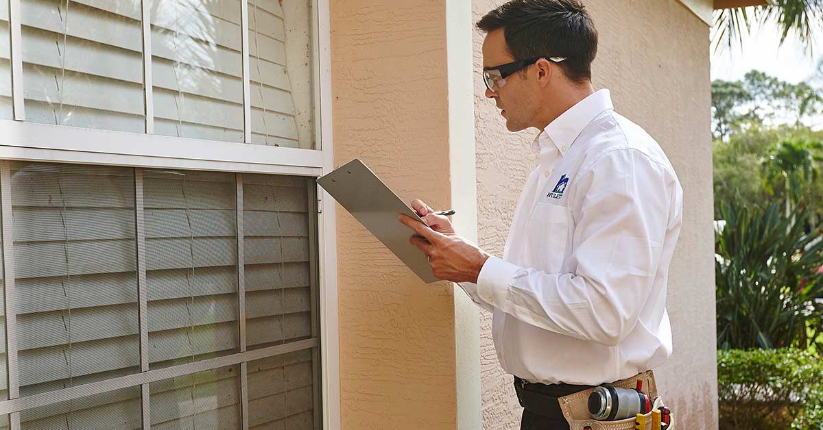 A technician inspecting a window.