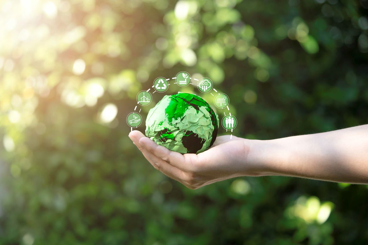 usinessman holding green scrap paper ball with world map and environment icon such as carbon reduction green factory recycle and solar cell for zero carbon emission credit to prevent global warming