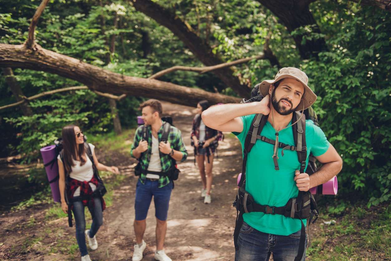 A group of hikers being bitten by mosquitos