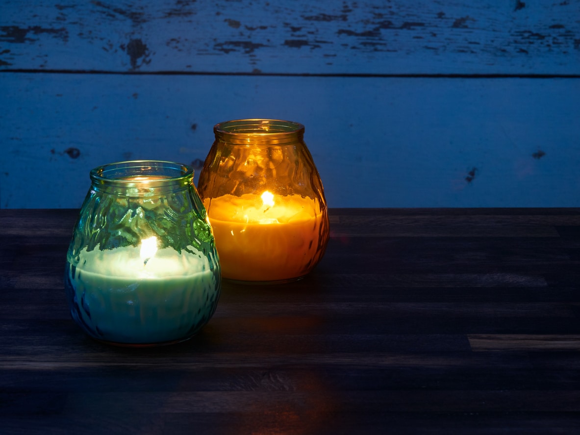 Green and orange citronella candles used as mosquito repellant.